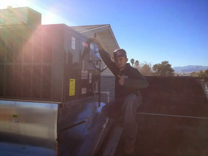 HVAC technician performing Air Duct Cleaning on a rooftop unit in Coventry